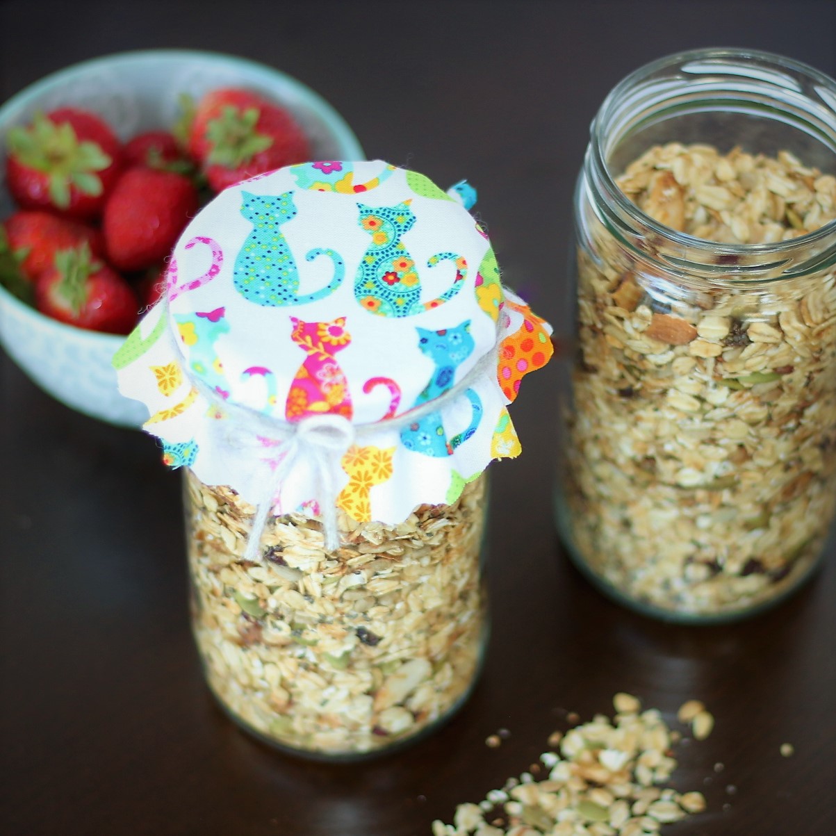 Muesli stored in tall jars trimmed with fabric for gifting.